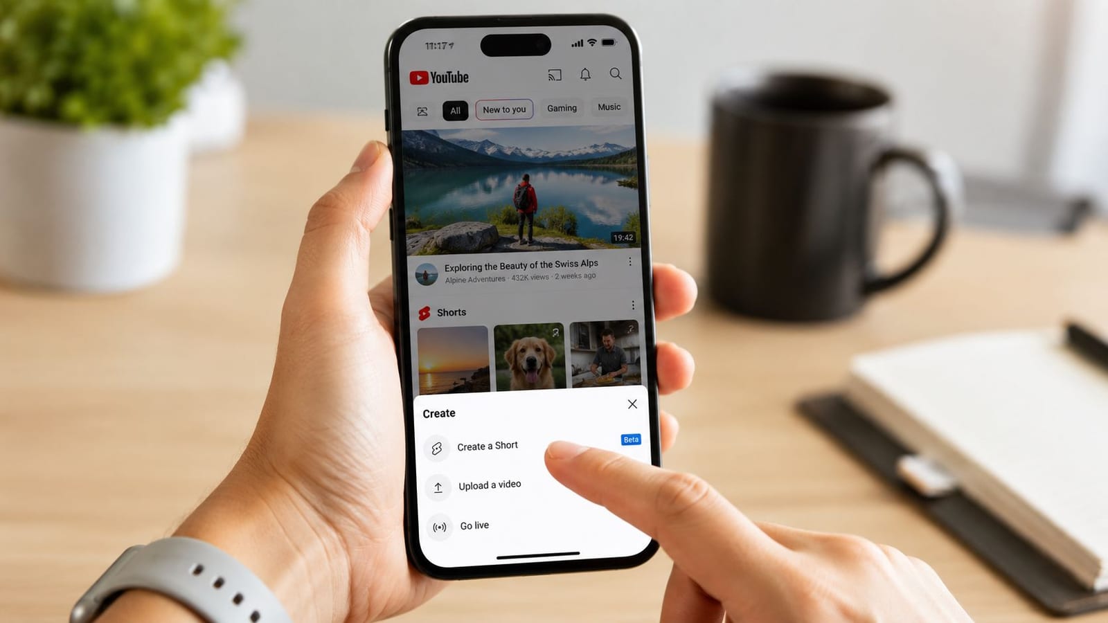 A person using a smartphone to open the Create menu on the YouTube mobile app interface.